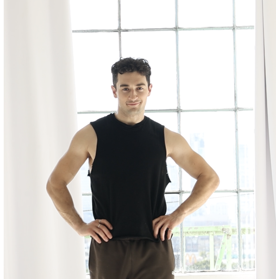 Ali standing in front of a bright studio window